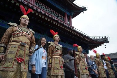 Foreign friends taking photos with popular warriors in golden armor at the city wall of Xi’an